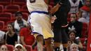 Pebasket Miami Heat, Jordan Mickey, berusaha memblok pebasket Golden State Warriors, Kevon Looney, pada laga NBA di American Airlines Arena, Miami, Senin (4/12/2017). Warriors menang 123-95 atas Heat. (AP/Joe Skipper)