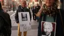 Seorang pengunjuk rasa memegang sebuah tanda dalam sebuah unjuk rasa untuk mendukung pendiri Wikileaks, Julian Assange di depan kedutaan besar Amerika Serikat di Madrid, pada tanggal 20 Februari 2024. (Thomas COEX/AFP)