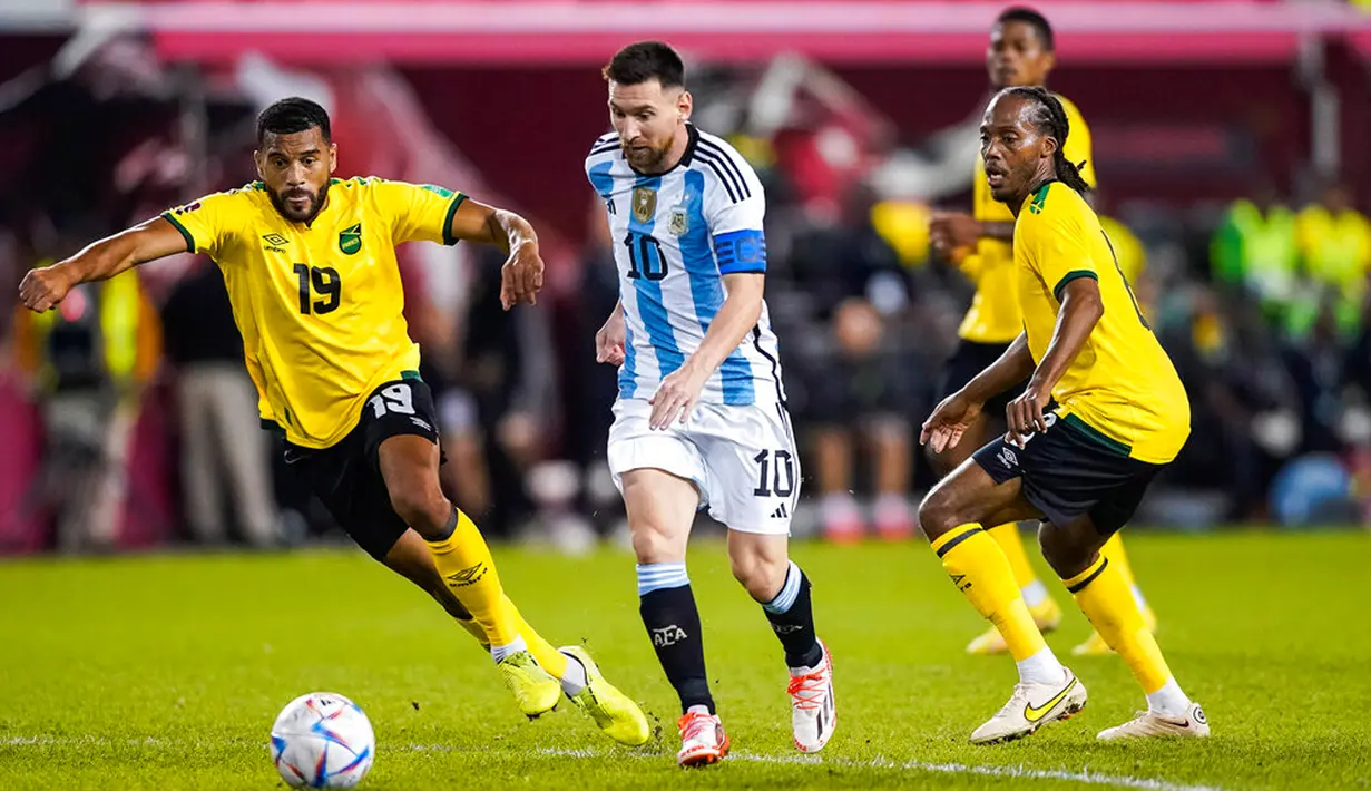Pemain Argentina Lionel Messi (kedua kiri) berebut bola dengan pemain Jamaika Adrian Mariappa (kiri) dan Daniel Johnson pada pertandingan persahabatan di Harrison, New Jersey, Amerika Serikat, 27 September 2022. Argentina menang 3-0 dengan Messi mencetak dua gol. (AP Photo/Eduardo Munoz Alvarez)