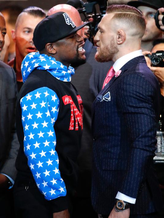 Petinju Floyd Mayweather Jr menatap Juara mixed martial arts Conor McGregor saat jumpa pers di Staples Center Los Angeles, AS (12/7). Mayweather dan McGregor akan bertanding pada 26 Agustus 2017. (AP Photo/Jae C. Hong)