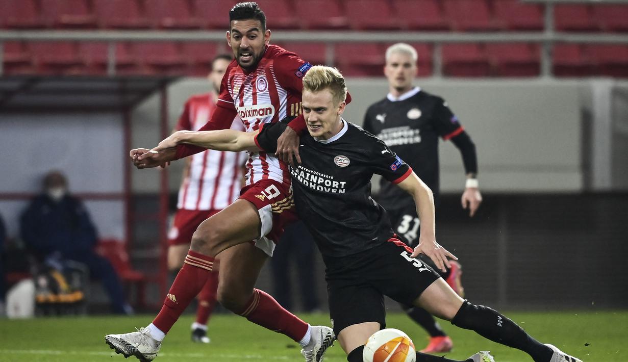 Bek PSV Eindhoven, Timo Baumgartl (kanan) berebut bola dengan striker Olympiacos, Ahmed Hassan pada laga leg pertama babak 32 Besar Liga Europa 2020/2021 di Georgios Karaiskakis Stadium, Piraeus (18/2/2021). Timo Baumgartl didatangkan PSV dari VfB Stuttgart pada awal musim 2019/2020 dengan nilai transfer 12 juta euro atau kini setara Rp199 miliar. Setelah dua musim membela PSV, sejak awal musim 2021/2022 ia dipinjamkan ke Union Berlin selama dua musim hingga akhir musim 2022/2023. (AFP/Aris Messinis)