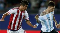 Victor Caceres (kiri) dari Paraguay menghentikan laju Lionel Messi dengan menarik bajunya di Copa America 2015, Cile. (REUTERS/Marcos Brindicci) 