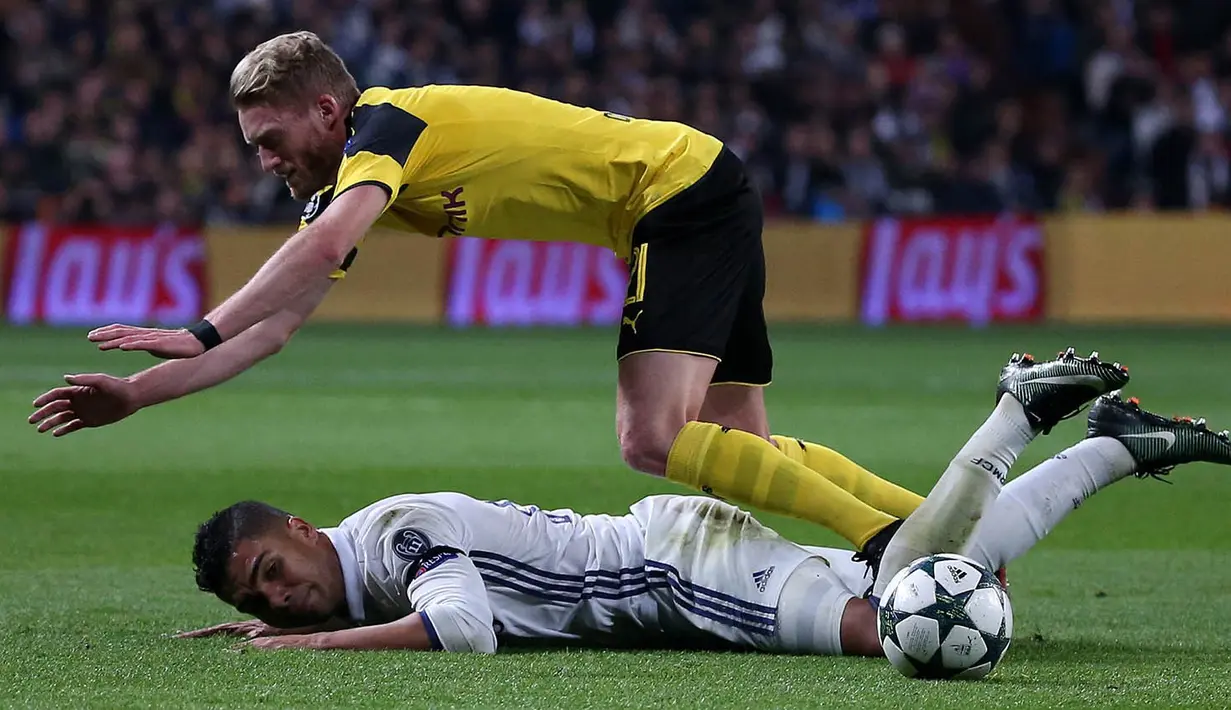Gelandang Real Madrid, Casemiro, dijatuhkan gelandang Dortmund, Andre Schurrle. Pada peringkat kedua, Real Madrid tertinggal dua poin dari Dortmund. (Reuters/Juan Medina)