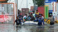Petugas mengevakuasi warga dengan perahu karet saat banjir rob di kawasan Pelabuhan Sunda Kelapa, Jakarta, Selasa (7/12/2021). Banjir rob setinggi satu meter memutus Jalan Kerapu yang menghubungkan Ancol-Pluit. (merdeka.com/Arie Basuki)