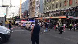 Kendaraan polisi terparkir di lokasi mobil menabrak kerumunan pejalan kaki di kawasan pusat bisnis Melbourne, Australia, Kamis (21/12). Menurut saksi mata, mobil itu menerobos lampu merah sebelum menabrak pejalan kaki. (Australian Broadcast Corp. via AP)