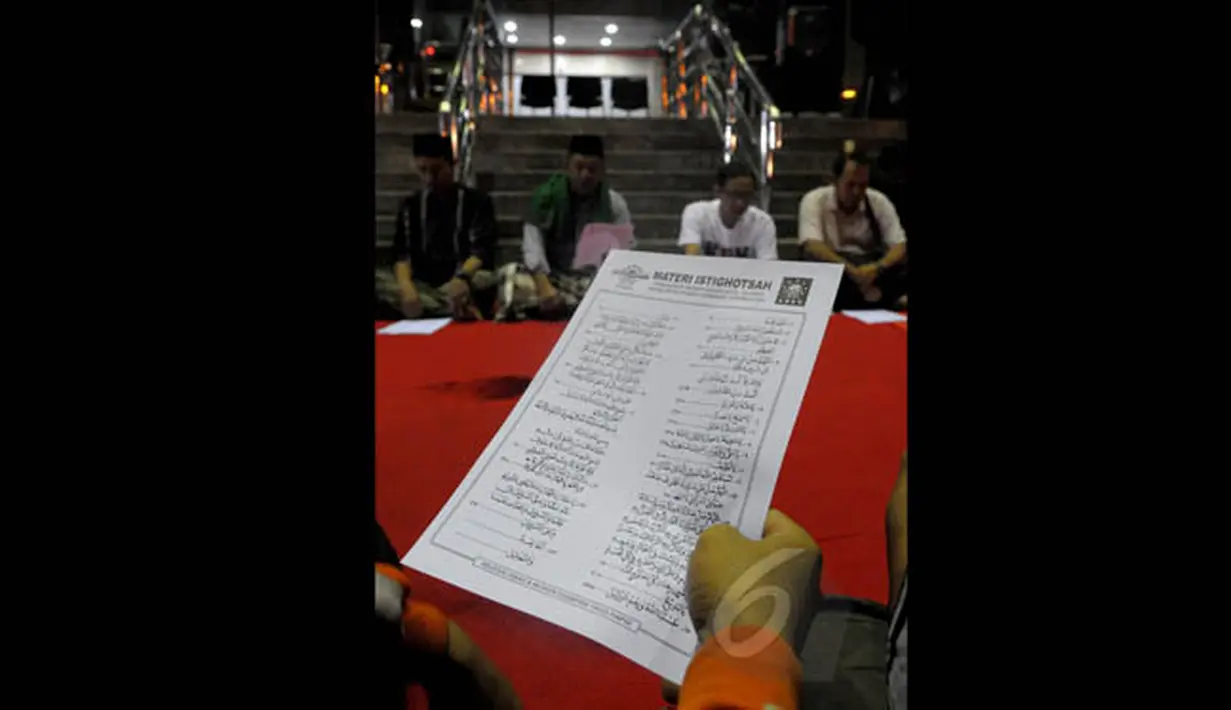 Sejumlah masyarakat menggelar istighosah di halaman Gedung KPK, Jakarta, Minggu (1/2/2015). Tampak selembar kertas doa sedang dibaca saat istighosah sebagai bentuk dukungan kepada Komisi Pemberantasan Korupsi (KPK)‎. (Liputan6.com/Andrian M Tunay)