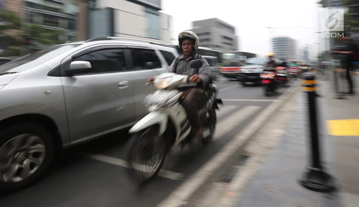 Kendaraan roda dua melintas di persimpangan kawasan Jalan MH Thamrin, Jakarta, Jumat (20/9). Untuk menekan angka kecelakaan di Ibu Kota, BPTJ Kementerian Perhubungan berencana membatasi volume sepeda motor di Jakarta.(Liputan6.com/Faizal Fanani)