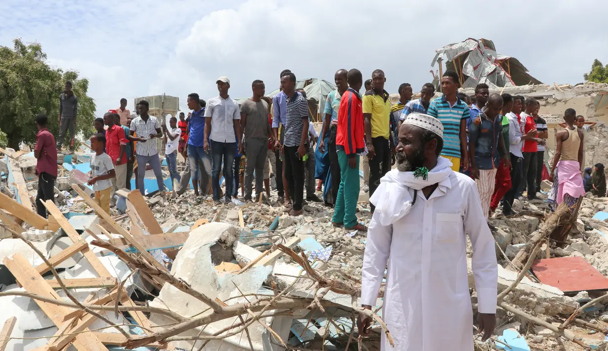 Warga Somalia berkumpul di lokasi ledakan bom mobil di luar kantor pemerintah lokal di Mogadishu, Somalia, (10/9). Menurut polisi Somalia dan pekerja penyelamat, enam orang tewas dan 16 luka-luka akibat ledakan tersebut. (AFP Photo/Abdi Haji Hussein)