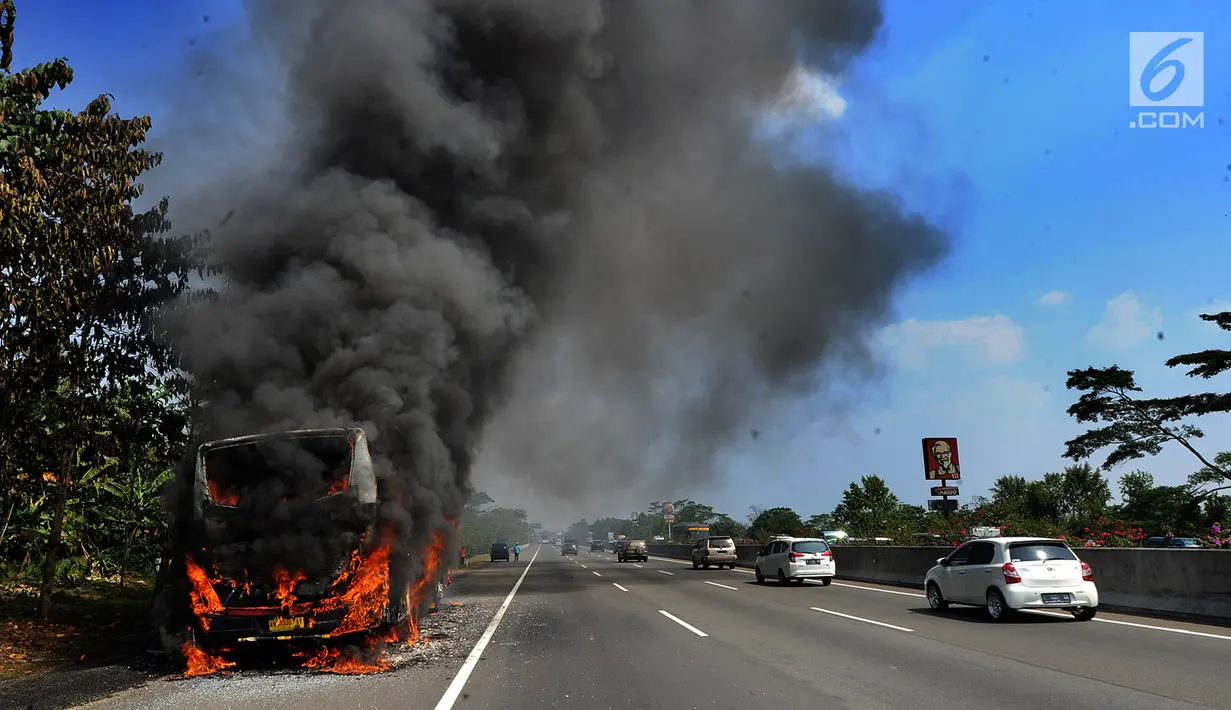 Sebuah bus pariwisata nopol AB 7536 AK terbakar pada ruas tol Jagorawi arah Bogor di KM 36, Bogor, kamis (25/7/2019). Bus kosong yang diawaki dua orang ini terbakar habis dengan api yang bersumber pada bagian AC bus. (merdeka.com/Arie Basuki)