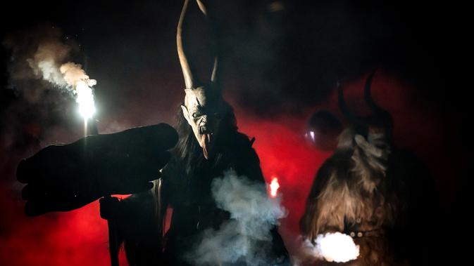 Partisipan berpakaian seperti Krampus, makhluk setengah iblis, saat ambil bagian dalam parade di kota Podkoren, Slovenia, Jumat (30/11). Tradisi natal ini juga dilakukan di beberapa negara seperti Austria, Jerman, Hungaria dan Ceko. (Jure Makovec/AFP)