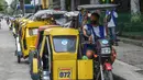 Seorang pengemudi taksi roda tiga menunggu penumpang di sebuah jalan di Manila, sehari sebelum pihak berwenang mencabut perintah tinggal di rumah pada Selasa (7/9/2021). Filipina akan mencabut lockdown di ibu kota Manila pada Rabu (8/9), saat kasus corona harian naik dua kali lipat. (Ted ALJIBE/AFP)