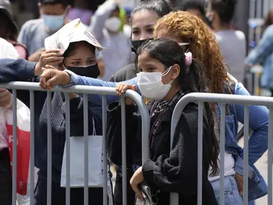 Orang-orang menunggu hasil tes PCR mereka untuk COVID-19 di sebuah pasar di Lima, Peru, Rabu (5/1/2022). Peru mengonfirmasi pada Selasa dimulainya gelombang ketiga infeksi virus corona di mana negara itu mencatat 309 kasus varian omicron yang sangat menular. (AP Photo/Martin Mejia)