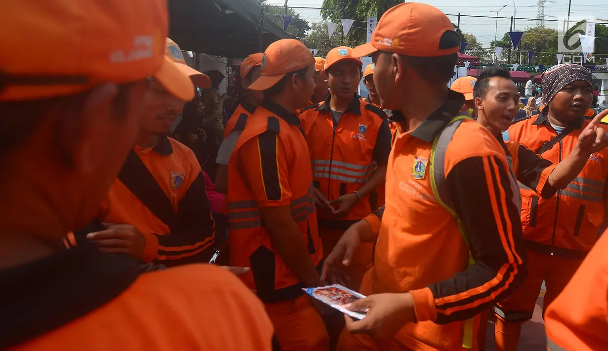 Petugas Penangganan Prasarana dan Saran Umum (PSSU) atau pasukan oranye mengantre sembako gratis di Jakarta, Jumat (3/8). Pembagian sembako gratis tersebut dalam rangka menyambut HUT ASABRI ke-47 tahun. (Merdeka.com/Imam Buhori)