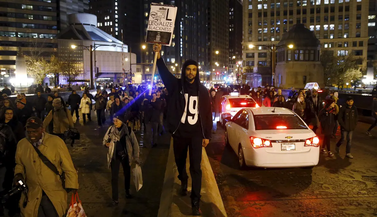 Aksi protes salah satu warga di jalanan Chicago, Illinois, Rabu (25/11). Ketegangan rasial memanas setelah rilisnya video kejadian seorang polisi kulit putih menembak remaja kulit hitam Laquan McDonald (17) pada Oktober 2014 (REUTERS/Andrew Nelles)