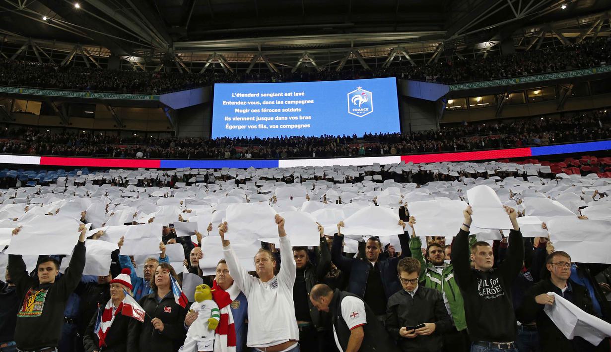 Suporter Inggris mengangkat kertas putih, yang merupakan bagian dari bendera Prancis pada laga Persahabatan antara Prancis vs Inggris di Stadion Wembley, London, Rabu(18/11/2015) dini hari WIB.  (AFP Photo/Ian Kington)