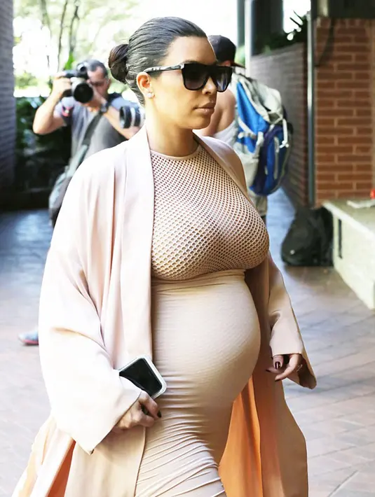 Kim tampak percaya diri melenggang di luar dan tetap menggenggam ponselnya yang selalu berguna. (via dailymail.co.uk)