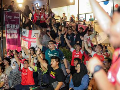 Pendukung Arsenal yang tergabung ke dalam AIS (Arsenal Indonesia Supporters) merayakan gol pertama timnya ke gawang Tottenham Hotspur yang dicetak oleh Pierre-Emile Hojbjerg saat Roaring Night Liga Inggris di The Ground at Nipah, Jakarta Selatan, Minggu (28/04/2024). (Bola.com/Bagaskara Lazuardi)
