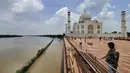 Pada hari Rabu, dinding pembatas batu pasir merah Taj Mahal dikelilingi oleh air berlumpur berwarna coklat, bahkan ketika sekumpulan turis memadati monumen bersejarah yang tidak tersentuh oleh sungai. (AP Photo/Aryan Kaushik)