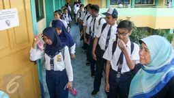Sejumlah peserta Ujian Nasional (UN) bersiap masuk ruang ujian di SMPN 41 Jakarta, Senin (9/5). UN tingkat SMP yang digelar pada 9-12 Mei 2016 ini diikuti 984 sekolah atau 156.320 siswa. (Liputan6.com/Yoppy Renato)