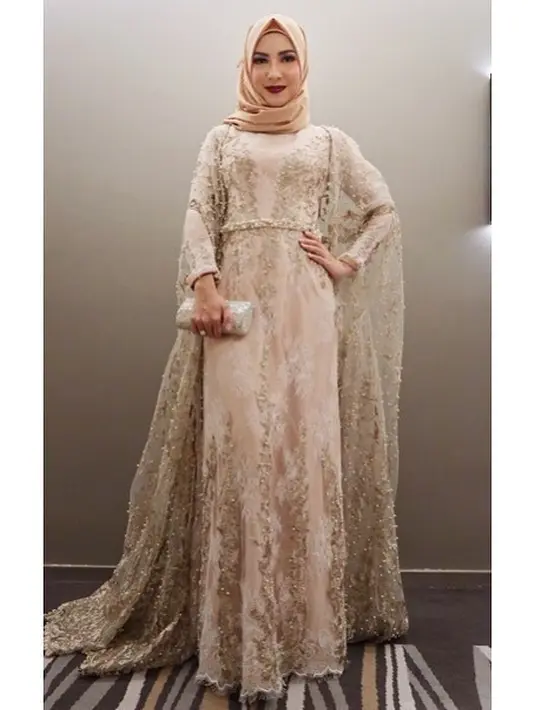 Selanjutnya adalah gaya Ratna memakai gaun berbahan brokat. Ratna memilih warna putih tulang dan modelnya yang panjang di bagian tangan, sehingga berbentuk seperti sayap. (Instagram/ratnagalih)