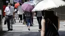 Orang-orang menggunakan payung di bawah terik matahari di Tokyo, Jepang, Selasa (10/8/2021). Menurut biro meteorologi Jepang, cuaca panas panas terus berlanjut di wilayah metropolitan saat suhu naik menjadi 38 derajat Celcius (100,4 derajat Fahrenheit). (AP Photo/Eugene Hoshiko)