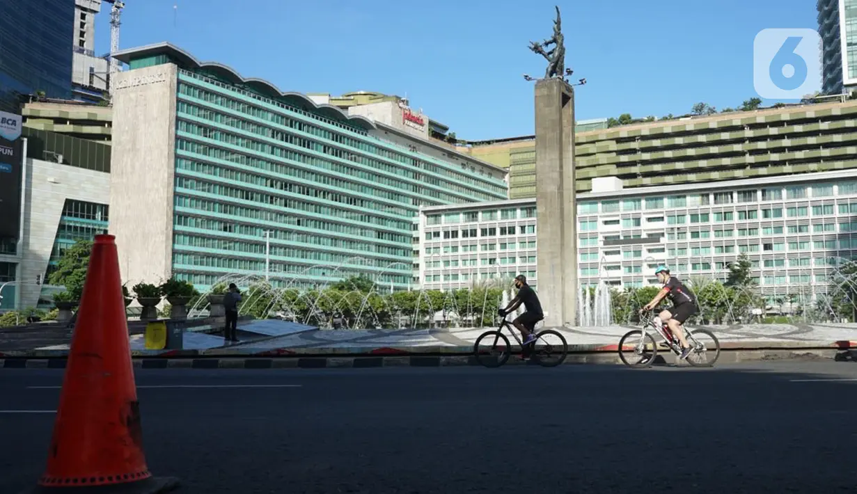 Sejumlah pesepeda melintas di kawasan Bundaran HI, Jakarta, Minggu (24/5/2020). Adanya PSBB serta Hari Raya Idul Fitri 1441 H dimanfaatkan sebagian warga untuk bersepeda di jalan protokol yang sepi dibanding hari biasa. (Liputan6.com/Immanuel Antonius)