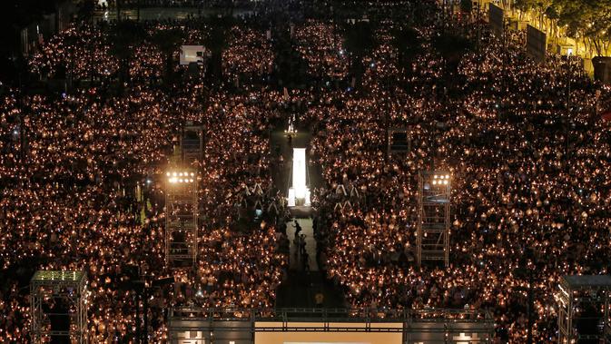 Puluhan ribu orang berkumpul sambil menyalakan lilin untuk memperingati Insiden Tiananmen di Taman Victoria Hong Kong (4/6). (AP/Vincent Yu)
