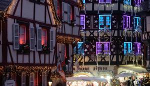 Pengunjung berjalan-jalan di pasar Natal di Colmar, Prancis timur, pada 7 Desember 2021. (SEBASTIEN BOZON/AFP)