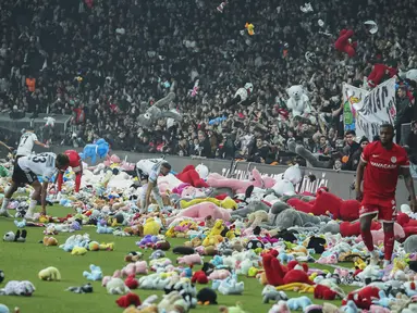 Suporter melempar mainan ke lapangan selama pertandingan Liga Turki (Super Lig) antara Besiktas dan Antalyaspor di stadion Vodafone, Istanbul, Minggu (26/2/2023). Selama pertandingan, para fans melemparkan sejumlah besar mainan lunak untuk disumbangkan kepada anak-anak yang terkena dampak gempa kuat pada 6 Februari di tenggara Turki. (AP Photo)