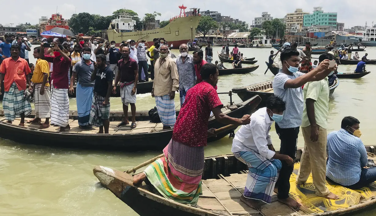 Warga menyaksikan proses evakuasi korban kecelakaan kapal feri di Sungai Buriganga, Dhaka, Bangladesh, Senin (29/6/2020). Kapal feri yang tenggelam mengangkut hingga 60 penumpang. (AP Photo/Al-emrun Garjon)