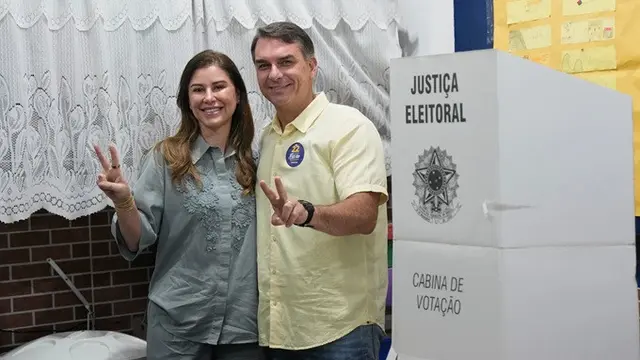 Calon presiden dari kubu oposisi, Senator Flavio Bolsonaro, bersama istrinya, Fernanda Bolsonaro, mengacungkan jempol saat berlangsungnya putaran kedua Pilpres di Rio de Janeiro, Brasil, Minggu (25/10/2026).