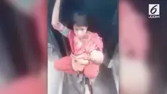 Bukannya duduk di salah satu gerbong, wanita ini memutuskan duduk di besi penghubung antar kereta sambil membawa sang bayi.