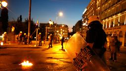 Polisi anti huru hara berjaga saat bentrok dengan unjuk rasa anti-bailot di Athena, Yunani, Rabu (15/7/2015). Unjuk rasa ini dilakukan menjelang pemungutan suara kesepakatan bailout. (REUTERS / Yannis Behrakis)