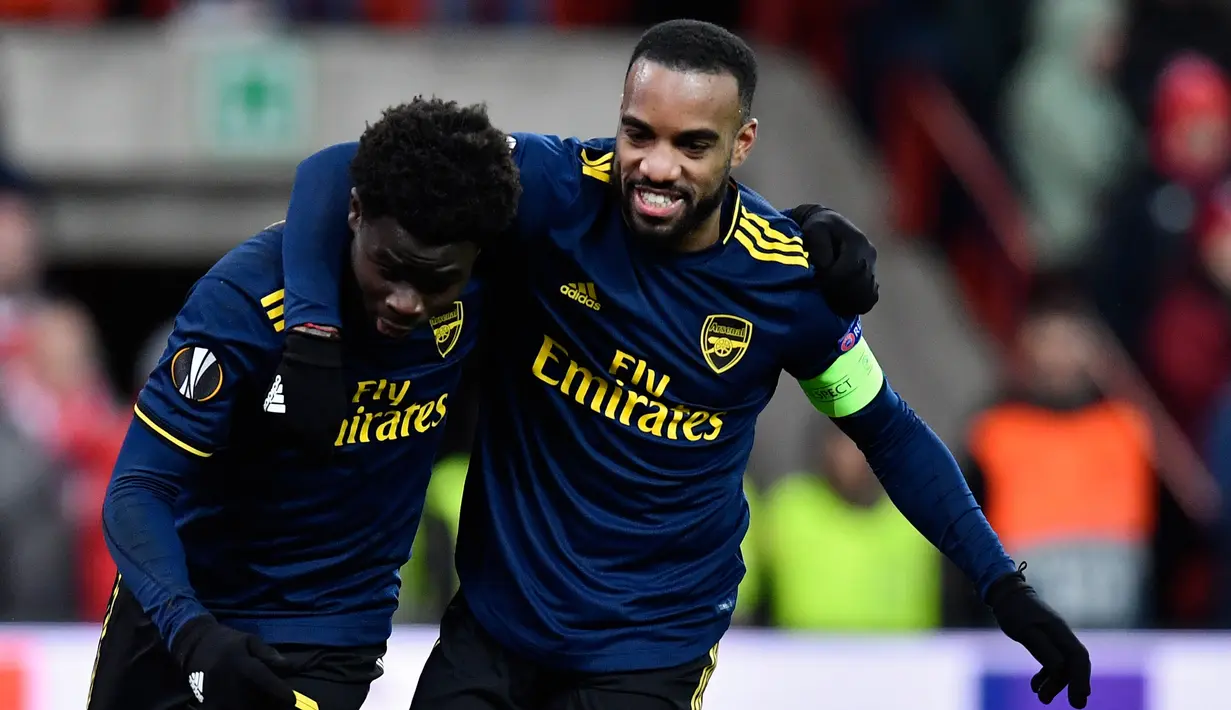 Pemain Arsenal Bukayo Saka (kiri) merayakan golnya ke gawang Standard Liege bersama Alexandre Lacazette pada pertandingan Grup F Liga Europa di Stadion Maurice Dufrasne, Liege, Belgia, Kamis (12/12/2019). Arsenal juara grup setelah menahan Standar Liege 2-2. (JOHN THYS/AFP)