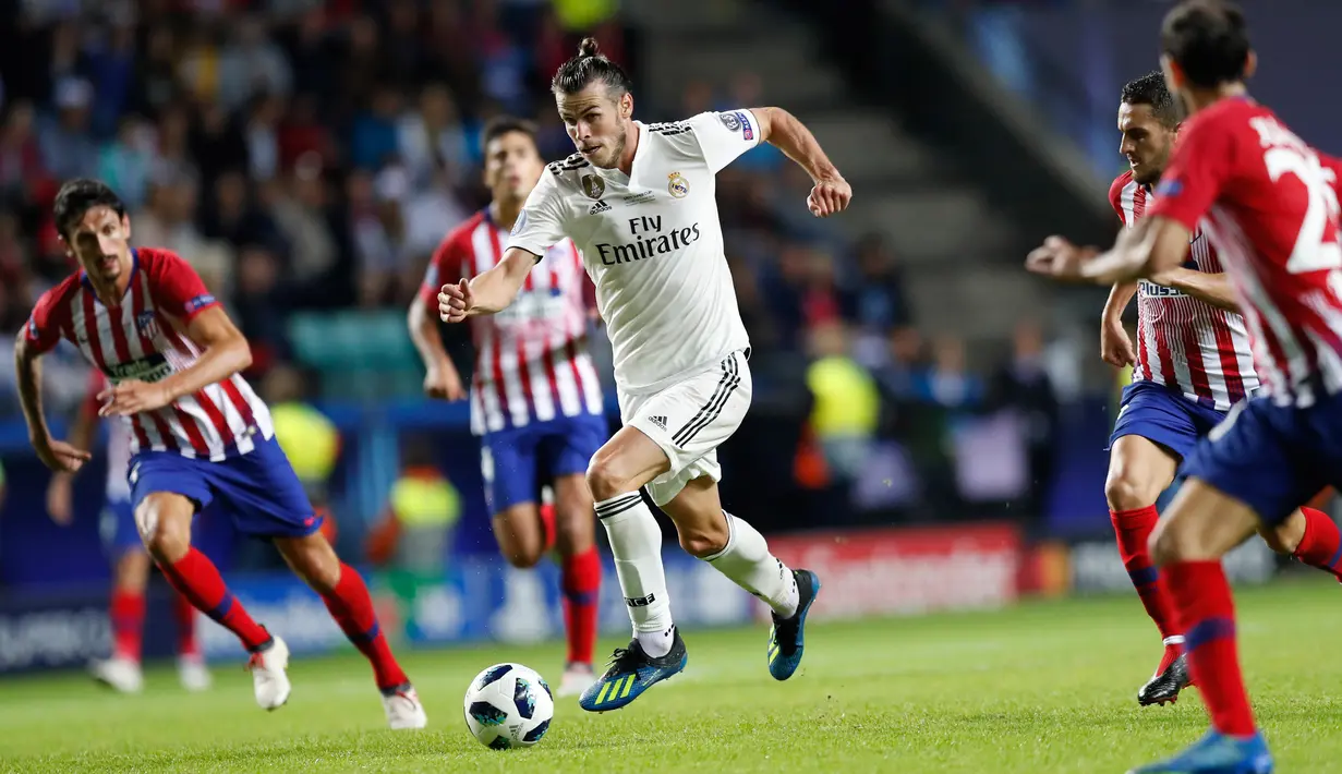 Gelandang Real Madrid, Gareth Bale menggiring bola dari kejaran pemain Atletico Madrid pada final Piala Super Eropa di Lillekula Stadium di Tallinn, Estonia, (15/8). Real Madrid kalah 4-2 atas Atletico. (AP Photo/Pavel Golovkin)
