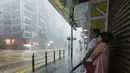 Beberapa warga berteduh menunggu Topan Kalmaegi reda di distrik Sentral Hong Kong, (16/9/2014). Topan Kalmaegi melanda Hong Kong mengakibatkan gangguan pada penerbangan dan memaksa penutupan pasar saham. (AFP PHOTO/Xaume Olleros)