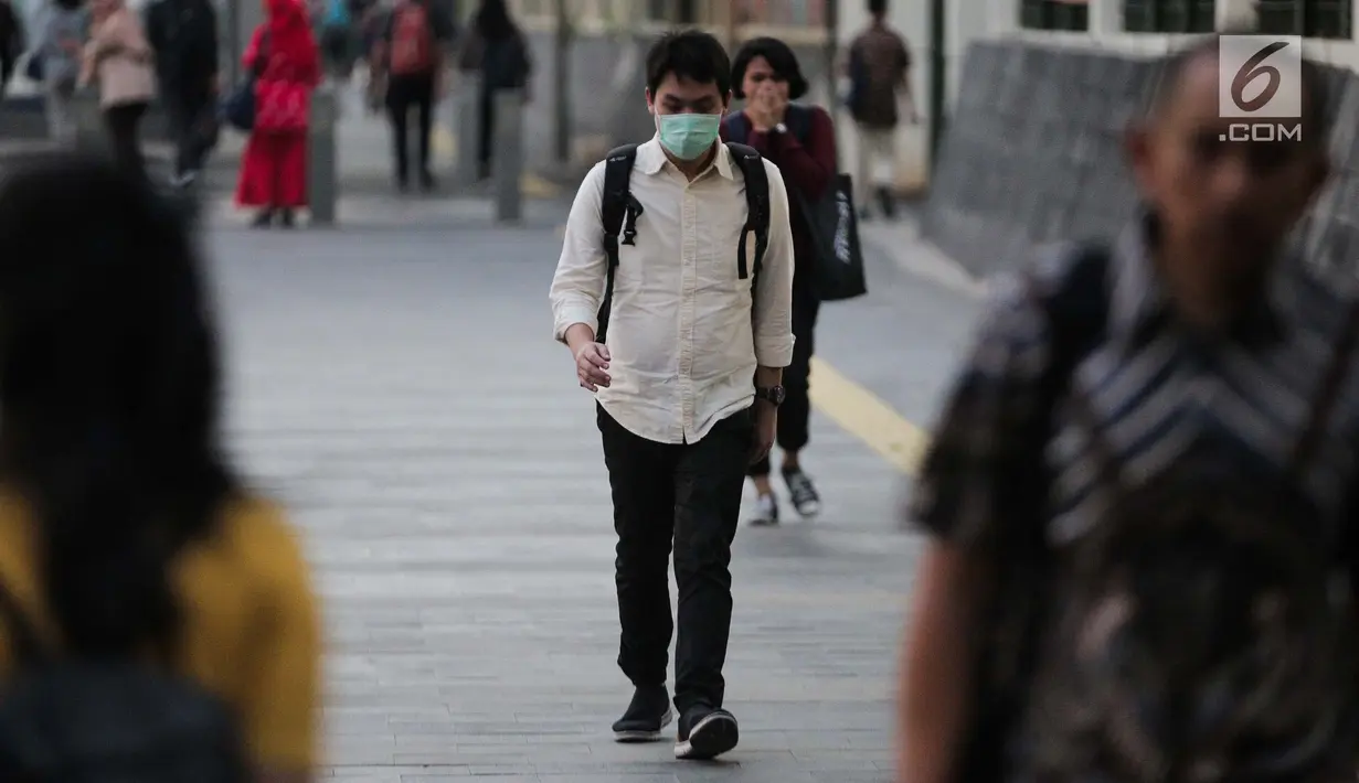 Seorang pria berjalan mengenakan masker pelindung untuk menghindari polusi udara buruk di Jakarta, Rabu (17/7/2019). Dinkes DKI menyarankan masyarakat untuk menggunakan masker saat beraktivitas untuk mencegah dampak polusi udara pada tubuh. (Liputan6.com/Faizal Fanani)
