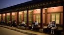 Gambar pada 4 Oktober 2019, wisatawan duduk di bangku dekat halaman saat kunjungan malam ke Istana Gyeongbokgung di Seoul, Korea Selatan. Kunjungan malam tersedia pada minggu ketiga dan keempat setiap bulan mulai dari 26 April sampai 31 Oktober, kecuali pada bulan Agustus. (Photo by Ed JONES / AFP)
