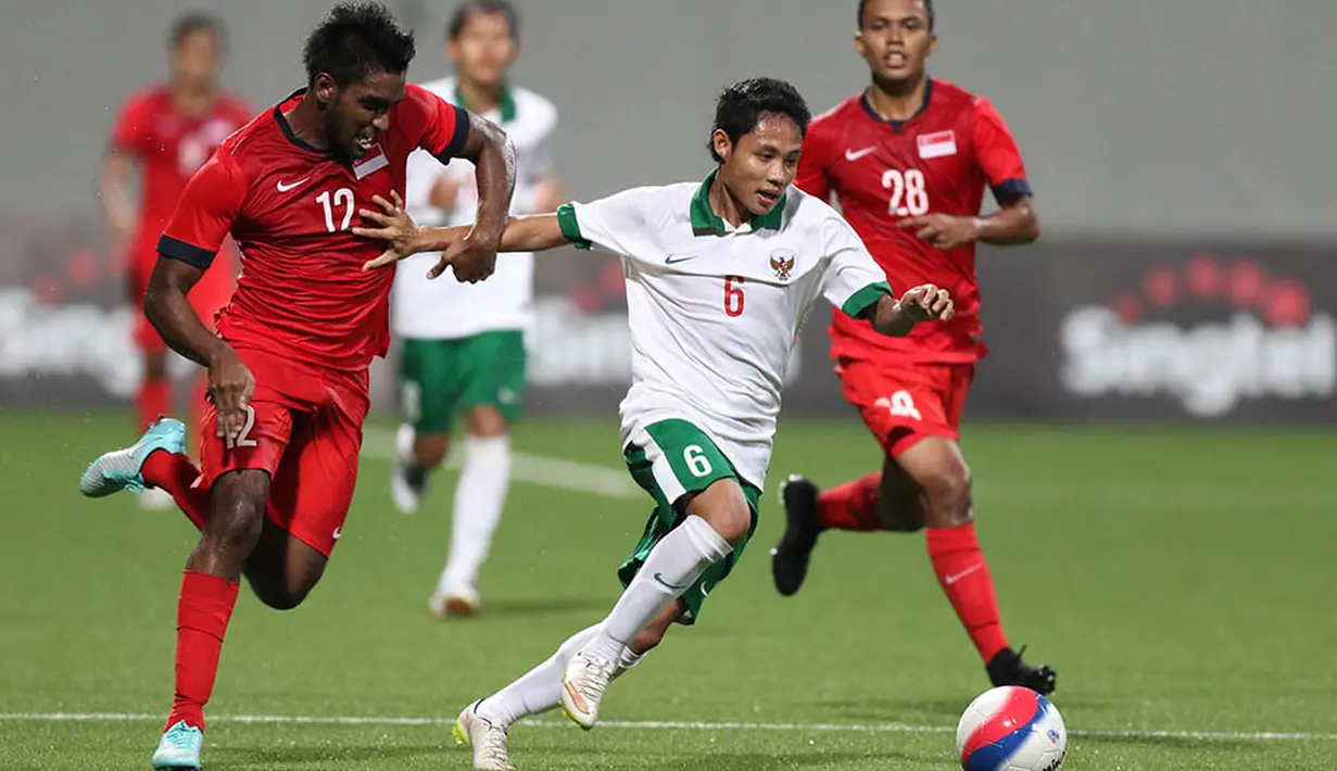 Gelandang Indonesia U-23, Evan Dimas, menggiring bola pada laga Sea Games melawan Singapura. Indonesia tahun 2015 mendapatkan sanksi dari FIFA yang melarang tim merah putih berlaga di ajang internasional. (Bola.com/Arief Bagus)