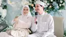 Alvin Faiz dan Henny Rahman mengadakan acara akikah untuk buah hati pertamanya, pada Kamis (30/3/2023). Pasangan tersebut tampak begitu serasi dengan busana putih. Tak hanya itu, dekorasi acara akikah tampak mewah dengan nuansa biru. (Liputan6.com/IG/@malycaphoto)