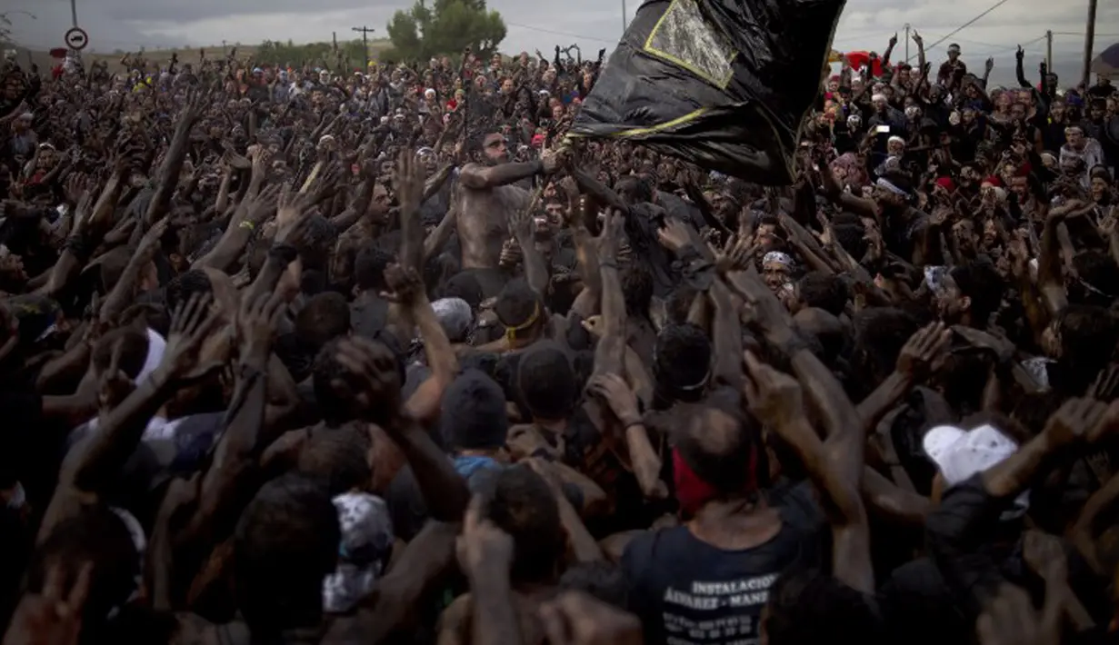 Peserta bersuka ria saat saling menyiramkan minyak dan cat hitam pada Festival Cascamorras di Baza, Spanyol, 6 September 2015. Festival ini diadakan setiap 6 September tiap tahunnya dan telah dilakukan selama 500 tahun terakhir. (AFP PHOTO/JORGE GUERRERO)