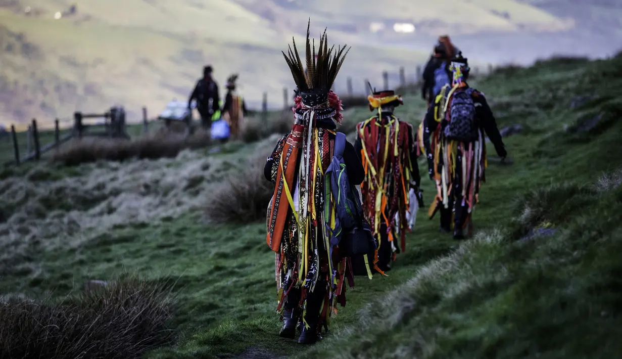 Anggota Powderkeg Morris Dancers meninggalkan Windgather Rocks usai melakukan festival Celtic kuno di High Peak di Derbyshire (1/5). Acara ini dirayakan pada May Day atau awal musim panas. (AFP Photo/Lindsey Parnaby)