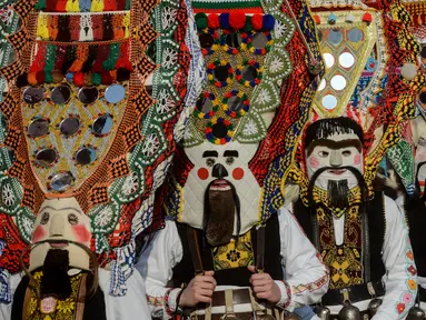 Penari yang dikenal sebagai "Kukeri" mengenakan kostum dan topeng saat tampil dalam Festival Internasional Masquerade Games di Pernik, Bulgaria (28/1). Festival kostum dan tarian ini digelar selama tiga hari. (AFP/Nikolay Doychinov)