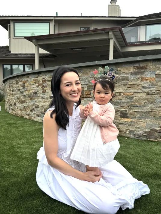 Sang anak memakai dress yang tampak begitu manis dengan paduan cardigan pink yang memikat.  [Foto: Instagram/ Julie Estelle]
