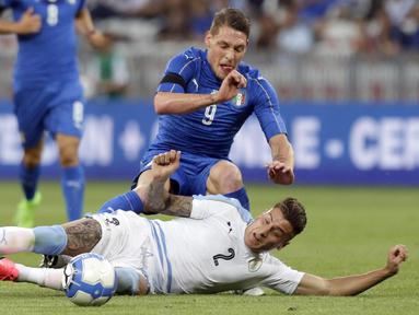 Pemain Italia, Andrea Belotti diadang pemain Uruguay,  Jose Gimenez (bawah)  pada laga Persahabatan di Nice Allianz Riviera stadium, Prancis, (7/6/2017). (AP/Claude Paris)