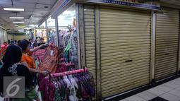 Seorang pembeli saat memilih pakaian di pasar Tanah Abang Blok C, Jakarta, Selasa, (22/7/2015). Usai liburan lebaran Pasar Tanah Abang akan normal kembali pada 27 Juli mendatang. (Liputan6.com/Faizal Fanani)