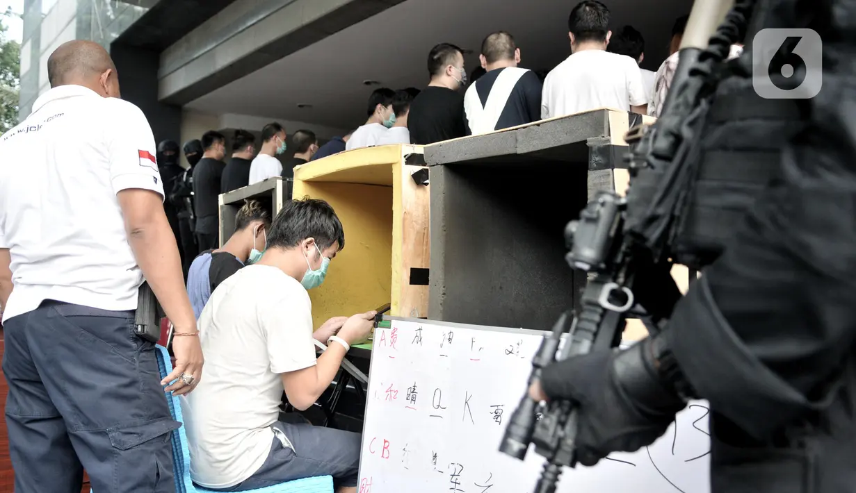 Dua tersangka mempraktikkan salah satu adegan saat rilis kasus penipuan online (Telecom Fraud) di Mapolda Metro Jaya, Jakarta, Selasa (26/11/2019). Polisi meringkus 91 tersangka yang merupakan warga negara (WN) China. (merdeka.com/Iqbal Nugroho)