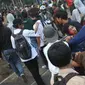 Sejumlah pelajar menggotong rekan mereka yang terluka dalam demonstrasi di belakang Gedung DPR, Palmerah, Jakarta, Rabu (25/9/2019). Pelajar bahu membahu membantu rekan mereka yang terluka dalam demonstrasi. (Liputan6.com/Angga Yuniar)