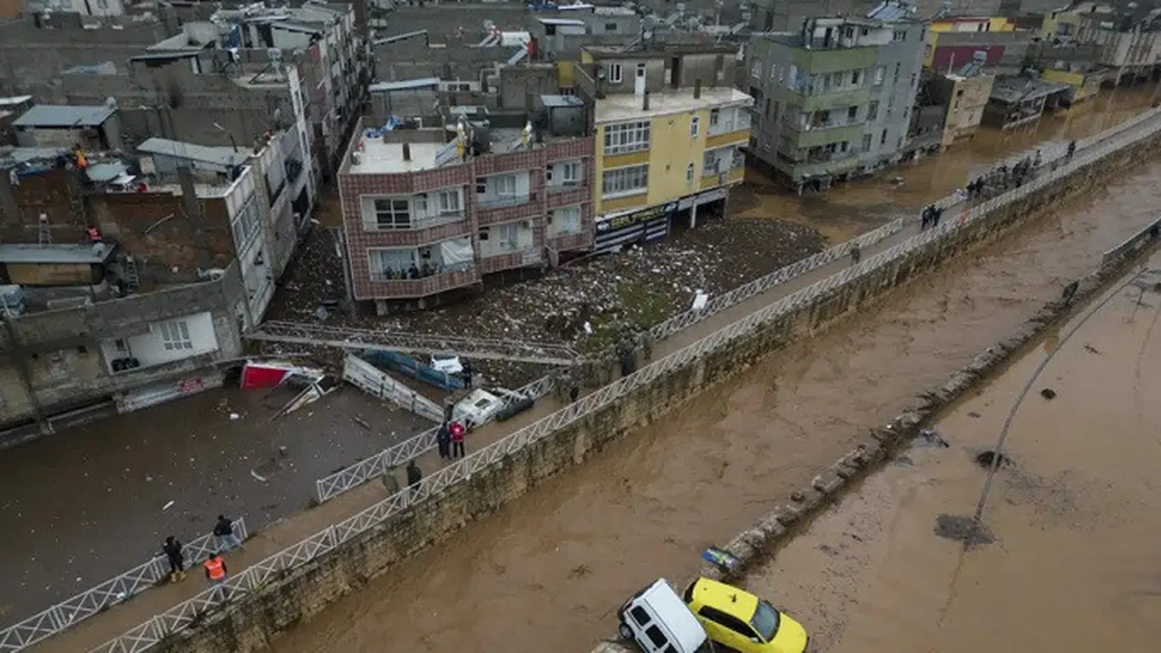 Kendaraan dan puing-puing berserakan akibat banjir di Sanliurfa, Turki, pada Rabu (15/3/2023). Banjir akibat hujan deras melanda dua provinsi yang porak-poranda akibat gempa bulan lalu, menewaskan sedikitnya 14 orang. (Dok. Hakan Akgun/AFP)