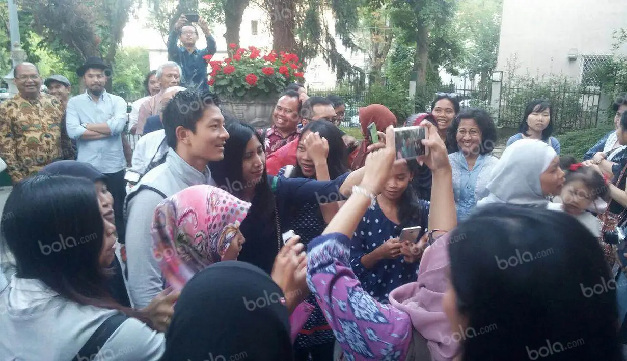 Pebalap Manor Racing asal Indonesia, Rio Haryanto, diajak berfoto bersama warga Indonesia saat hadir dalam acara meet and greet di Kantor KBRI Wina, Austria, Selasa (28/6/2016). (Bola.com/Reza Khomaini)